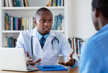 African american doctor has bad news for male patient at hospital